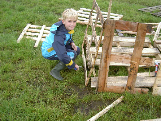op de knieën in de modder...